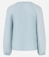 Blusa de crepé en color verde agua claro, con cuello redondo y mangas largas voluminosas. Presenta un diseño con textura plisada tanto en las mangas como en el cuerpo de la prenda, con puños ajustados.