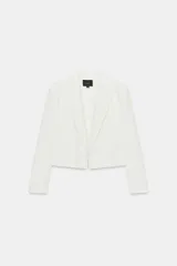 Blazer crop color blanco de cuello solapa y manga larga con hombreras. Forro interior combinado a tono.