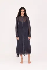 Vestido camisero largo midi de calce recto, confeccionado en tejido liviano y semitransparente de color azul oscuro. Presenta cierre frontal con botones, cuello mao, mangas largas con puño y terminaciones irregulares en el bajo.