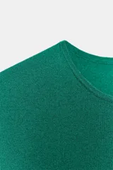 Top corto de punto color beige claro, con cuello redondo y mangas cortas tipo hombrera.