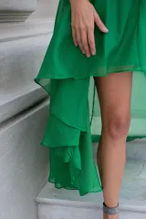 Vestido largo de gasa color verde esmeralda con detalles de lurex, un solo hombro y volados. Incluye viso elastizado al cuerpo.