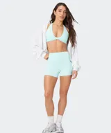 Top deportivo Fabletics modelo PureLuxe color verde militar, con diseño cruzado en la parte delantera y tirantes halter.
