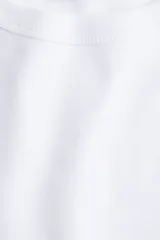 Remera de algodón blanca, de manga corta y cuello redondo acanalado, corte clásico y diseño liso.
