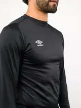 Remera térmica de manga larga Umbro, color negro, con cuello redondo y ajuste al cuerpo. Presenta el logo de la marca estampado en blanco en el pecho.