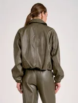 Chaqueta bomber de eco cuero color verde oliva, con cuello tipo solapa, cierre frontal metálico, bolsillos laterales y puños elásticos.