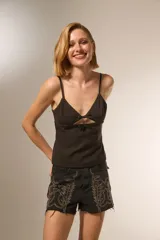 Musculosa negra de bretel fino con escote en V, detalle de aberturas frontales con lazos y pinzas de entalle.