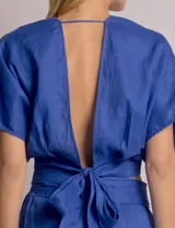 Blusa corta cruzada de lino, marca Elan, color azul. Presenta corte crop, escote en V pronunciado, mangas cortas amplias estilo kimono y lazo ancho para anudar en la espalda.