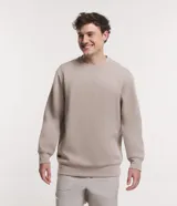 Buzo deportivo color beige de manga larga con cuello redondo y etiqueta aplicada en el lateral. Confeccionado en tejido de poliéster, viscosa y elastano, de secado ultrarrápido, ligero y cómodo.