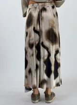 Pollera larga de tiro alto con estampado abstracto en tonos grises y marrones.