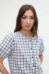 Camisa a cuadros de manga corta abullonada y cuello redondo, con cierre frontal de botones.