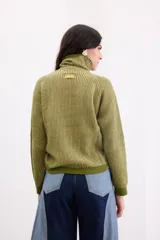 Sweater de cuello tortuga con diseño rayado vertical en tonos verdes. Confeccionado en tejido de punto con sutiles destellos de lurex, presenta un corte recto y mangas largas.
