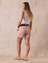 Short de jean azul con pretina con pasadores, cierre y doble abotonadura. Delantera y trasera con bolsillos. Incluye cinturón trenzado marrón.