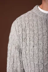 Sweater de punto color gris claro, con cuello redondo y diseño de tejido trenzado.