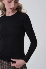 Remera de manga larga ajustada al cuerpo, color blanco, con cuello redondo bajo y tejido acanalado.