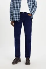 Pantalón de pana azul marino, corte slim fit, tiro medio y confeccionado con 83% algodón, 15% poliéster y 2% elastano.