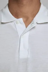 Chomba de piqué color blanco, de corte slim fit, manga corta y cuello camisero con cierre frontal de botones.