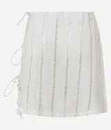 Minifalda de playa color crudo, con detalles de laise calado y ajuste lateral con lazos terminados en caracoles.