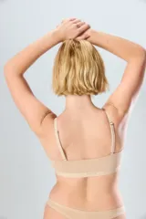 Top deportivo blanco con tirantes ajustables y diseño sin costuras.