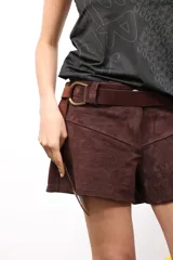 Cinto de cuero flexible color marrón oscuro, diseñado para anudar libremente y definir la silueta. Presenta una hebilla metálica dorada y el logo de la marca grabado en el extremo.