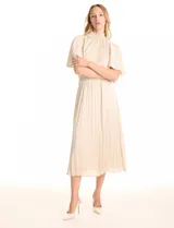 Vestido midi color beige de satén, marca Julia Jordan. Cuello alto con punto smock, mangas amplias de estilo fluido y cintura elastizada también con punto smock. La falda tiene una caída fluida con plisado. Cierre posterior con abertura ojal y botones. Forro interno a tono.