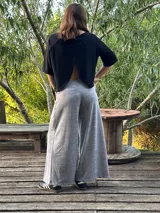 Blusa color beige de viscosa elastizada, con cuello bote y espalda cruzada. Estampado frontal con ilustración de una cara con corona de flores.