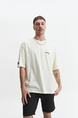 Remera de manga corta color crema, corte oversize, con cuello redondo y estampado con texto y diseño floral en el frente.