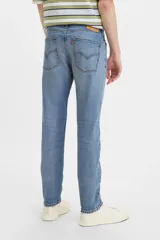 Jean de corte skinny con tiro medio, confeccionado en denim azul con efecto de lavado desgastado.