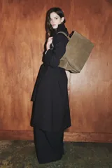 Bolso de hombro formato maxi city confeccionado en piel de gamuza color marrón. Cuenta con doble asa de hombro, doble compartimento interior y cierre mediante clip metálico y cremallera.