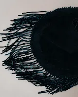 Cartera tipo hobo de gamuza color beige, con diseño amplio y detalle de flecos largos en todo el contorno. Cuenta con un asa superior con pespuntes artesanales y cierre principal.