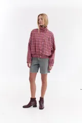 Chaqueta bomber de algodón con estampado a cuadros en tonos azules, amarillos y marrones, cuello alto y cierre frontal descentrado con botones. Cuenta con mangas abullonadas y puños elásticos.