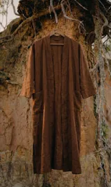 Kimono de largo midi en color marrón, con calce relajado y fluido. Presenta mangas amplias, bolsillos laterales y aberturas en el ruedo, confeccionado en un tejido liviano de textura natural.