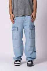 Jean cargo de corte baggy y tiro medio, confeccionado en denim de color celeste con lavado soft. Presenta bolsillos laterales tipo cargo con solapa, costuras reforzadas en las rodillas y un calce holgado con caída relajada.