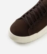 Championes de estilo casual con capellada de gamuza sintética en color marrón oscuro y suela de plataforma en tono crema con diseño estriado.