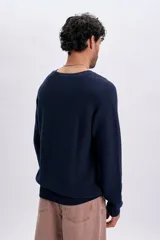 Buzo tejido de punto color azul marino, con cuello redondo y mangas largas con diseño raglán.