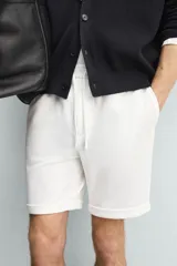 Bermuda regular fit de tejido elástico color blanco, con cintura elástica ajustable mediante cordón, bolsillos delanteros y bolsillos traseros de vivo.