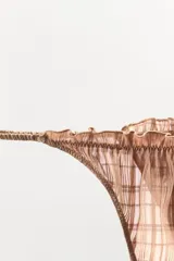 Tanga de tiro medio con diseño de cuadros, confeccionada en tejido semitransparente con detalles de elásticos fruncidos y acabados en volantes a tono.