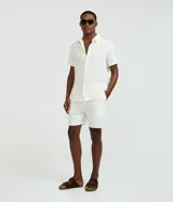 Bermuda de hombre Marfinno confeccionada en tejido texturizado con patrón vertical, color blanco, de corte recto, con cintura elástica y bolsillos.