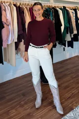 Pantalón de corte recto y ajuste entallado, color blanco, con cierre frontal y cinto negro incluido. Cuenta con bolsillos laterales y diseño de tiro medio.