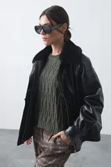 Campera de cuero sintético con acabado satinado, silueta relajada y elástico en la cintura. Presenta cuello con textura de piel sintética, cierre frontal y bolsillos laterales.