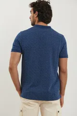 Remera polo de manga corta en color azul oscuro con estampado de pequeños puntos celestes. Presenta cuello clásico, cierre frontal con dos botones y terminaciones acanaladas en las mangas.