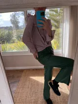 Pantalón slouchy de cuero ovino color verde inglés, corte mom fit con tiro semi alto y tajos inferiores.