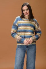 Sweater de punto con diseño de franjas horizontales en tonos mostaza, celeste, crudo y chocolate. Presenta cuello redondo y mangas largas con corte relajado.
