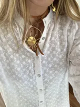Gargantilla con tira de cuero sintético marrón y dije dorado con forma de sol.
