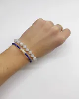 Conjunto de dos pulseras de cuentas, una compuesta por esferas translúcidas de piedra natural y otra más fina con cuentas facetadas de lapislázuli azul y perlas en el centro.