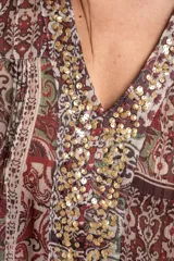 Blusa de manga corta con estampado estilo paisley en tonos burdeos, verde y crudo, escote en V con apliques de lentejuelas doradas y diseño holgado.