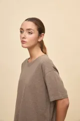 Remera negra de calce amplio, confeccionada en algodón liviano, con cuello redondo, mangas cortas y hombros levemente caídos.