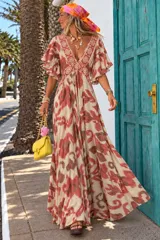 Vestido largo de diseño fluido con estampado geométrico en tonos beige y bordó, escote en V profundo con detalles bordados, mangas cortas acampanadas y falda amplia con movimiento.