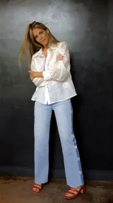 Pantalón de jean celeste con spandex y detalle de apliques de mariposas plateadas en los laterales. Corte recto y tiro medio.