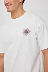 Remera de algodón color celeste pálido con cuello redondo y manga corta. Presenta un pequeño estampado frontal de un sol estilizado en tonos naranja y azul.