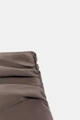 Falda pantalón de tiro medio en color negro, con diseño de pliegues en la parte superior y volantes en el ruedo. Cuenta con cierre lateral.